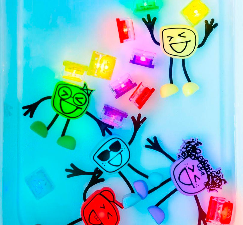 mesa sensorial con los muñecos de Glo Pals en varios colores