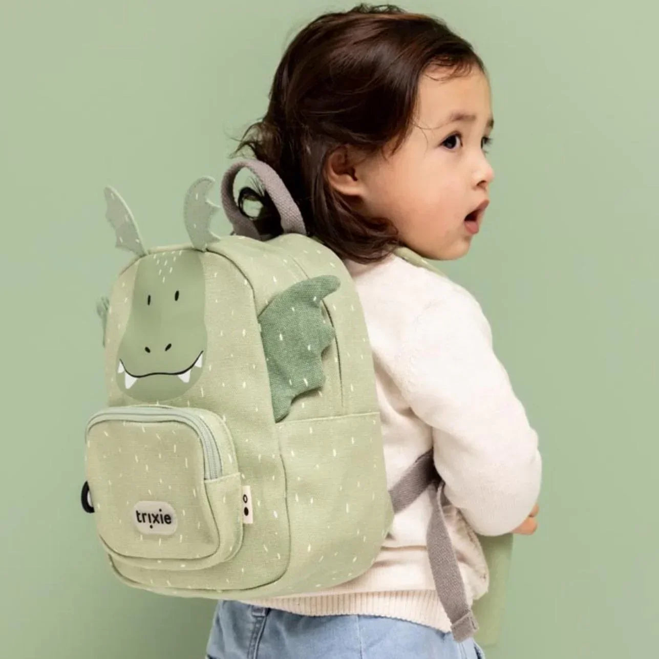 La Mochila Dragón Trixie es mucho más que un accesorio escolar: es el amigo inseparable de tu peque para la guardería, el parque o cualquier pequeña gran aventura. Diseñada pensando en la comodidad, autonomía y seguridad de los más pequeños, es ideal para niños a partir de 0-3 años, etapa de escuelita infantil.
Con su divertido diseño de dragón y tamaño adaptado a manos pequeñas, esta mochila combina funcionalidad con mucha personalidad. Dispone de un amplio compartimento principal y un bolsillo delantero