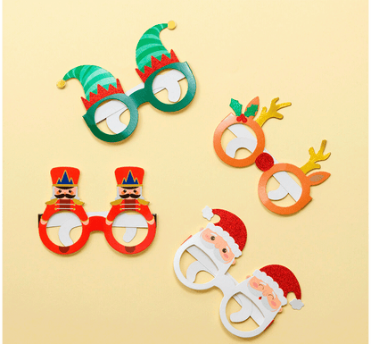 Foto lifestyle Set de 8 gafas navideñas de papel de Legami.  Elige tu personaje escogiendo una de las 8 formas diferentes con temática navideña. Déjate iluminar por los detalles laminados y la purpurina y sorprende con tu mejor pose en estas fiestas. ¡Fa-bu-lo-sas!!