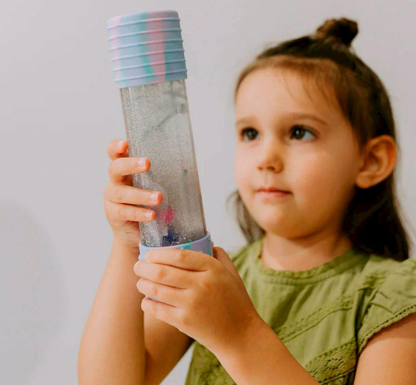 niña jugando con botella DIY Calm Down es una botella sensorial única, que una todos los elementos creativos necesarios para crear una botella sensorial perfecta