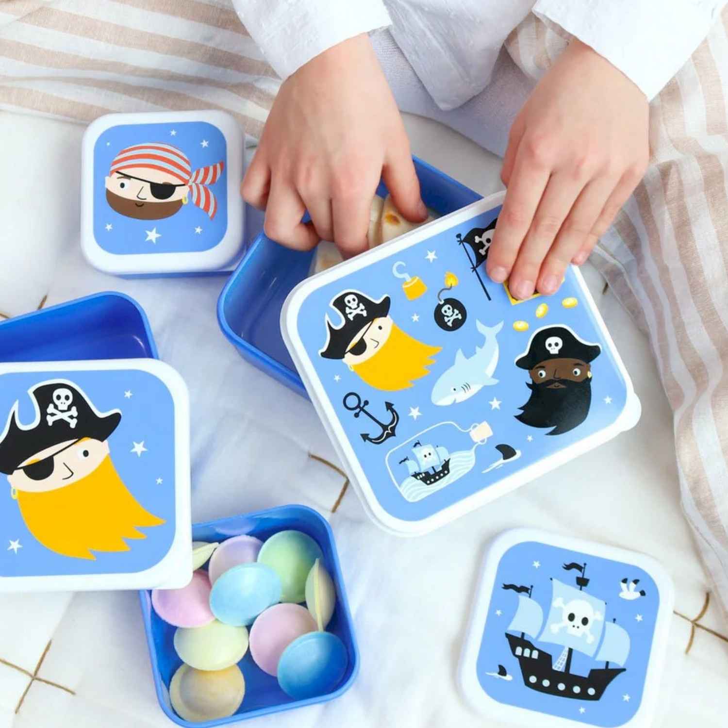 4 cajitas de almuerzo apilables con divertido diseño de piratas es el aliado perfecto para la merienda o el tentempié escolar. Al contar con cuatro dimensiones distintas, te permite llevar por separado alimentos variados sin mezclar sabores ni texturas. Son superligeras, muy resistentes al ritmo diario y su estructura nido permite encajarlas todas dentro de la caja mayor,