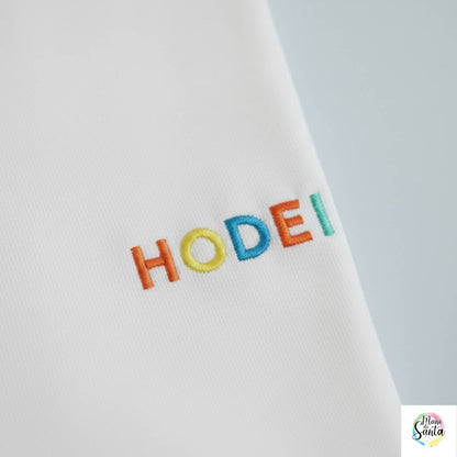 Compra la camiseta infantil personalizada con nombre bordado en relieve multicolor de Mano de Santa. Algodón premium 100% resistente y suave para niños.