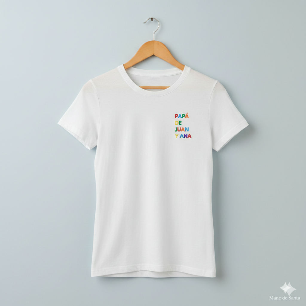 Camiseta Personalizada para Papá Blanca - "Papá de (Nombre)" - Bordado Multicolor Premium. Fabricada en tejido 100% algodón prelavado de alto gramaje (190g/m2). Corte contemporáneo moderno, construcción tubular y tacto ultrasuave. Incluye cuello de canalé fino y cinta tapacosturas trasera para mayor durabilidad. El regalo con más sentimiento para el Día del Padre, diseñado por Mano de Santa. Disponible en tallas de la XS a la 5XL.