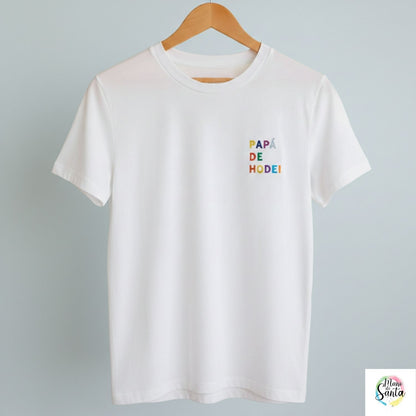 Camiseta Personalizada para Papá Blanca - "Papá de (Nombre)" - Bordado Multicolor Premium. Fabricada en tejido 100% algodón prelavado de alto gramaje (190g/m2). Corte contemporáneo moderno, construcción tubular y tacto ultrasuave. Incluye cuello de canalé fino y cinta tapacosturas trasera para mayor durabilidad. El regalo con más sentimiento para el Día del Padre, diseñado por Mano de Santa. Disponible en tallas de la XS a la 5XL.