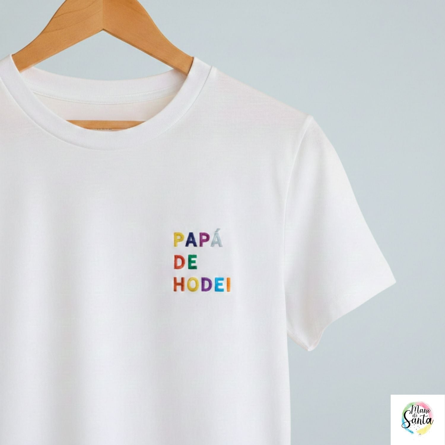 Camiseta Personalizada para Papá Blanca - "Papá de (Nombre)" - Bordado Multicolor Premium. Fabricada en tejido 100% algodón prelavado de alto gramaje (190g/m2). Corte contemporáneo moderno, construcción tubular y tacto ultrasuave. Incluye cuello de canalé fino y cinta tapacosturas trasera para mayor durabilidad. El regalo con más sentimiento para el Día del Padre, diseñado por Mano de Santa. Disponible en tallas de la XS a la 5XL.