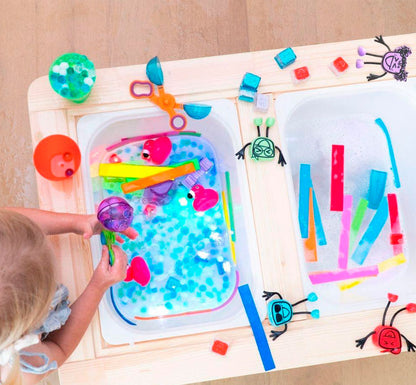 mesa de experimentación con los juguetes de Este personaje, incluye un hueco donde colocar el  cubo de luz, es un producto que capta la atención y centra los sentidos, a la vez que hace del baño una experiencia divertida. Se trata de un juguete que estimulará cognitiva y sensorialmente a los más pequeños