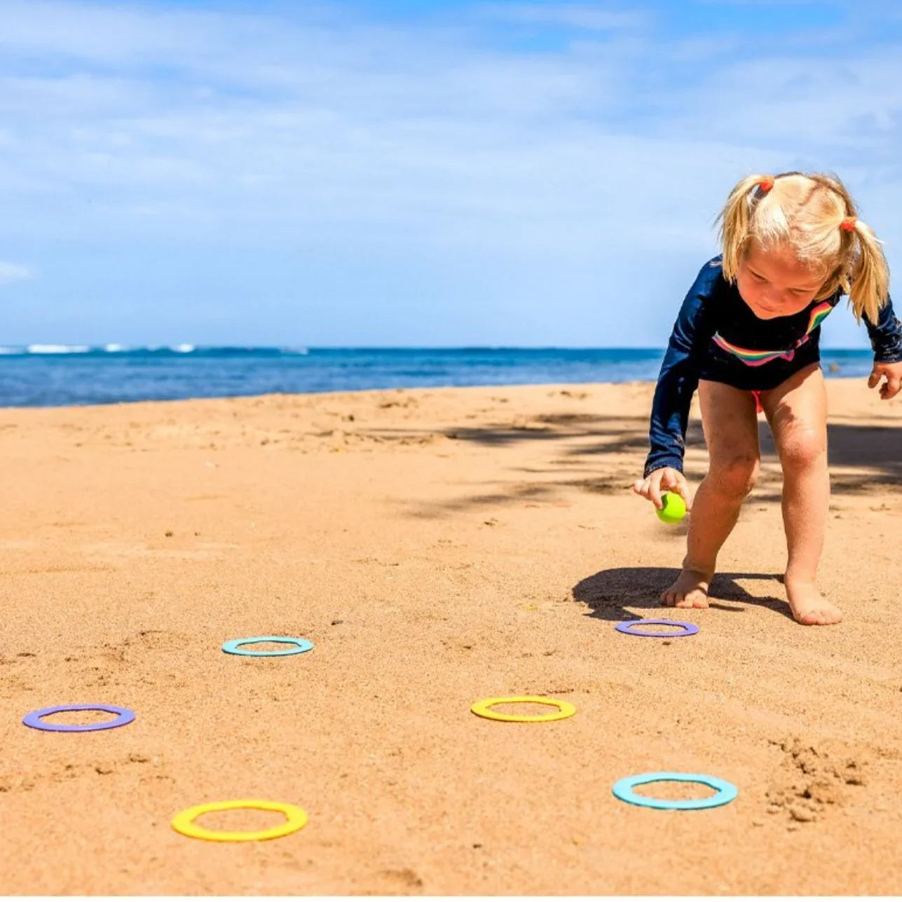 RiBi! Este versátil set de Bibio Toys invita a los peques a imaginar, moverse y crear sus propios retos, ya sea en la playa, la piscina, el parque o en casa.

¿Cómo se juega? Muy fácil: lanza la bola al centro de los aros en el suelo o sobre el agua y afina tu puntería. Luego, cambia el reto: coloca la bola y lanza los aros para encestar. ¡Y si lo prefieres, convierte los discos en barquitos flotantes o crea un circuito de obstáculos!