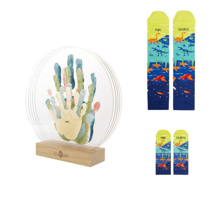Consigue el Pack Familia Papá Oso en Mano de Santa. Incluye el marco transparente de huellas de Petit Artichaut y calcetines a juego para papá e hijo. ¡El regalo familiar más tierno y creativo!
