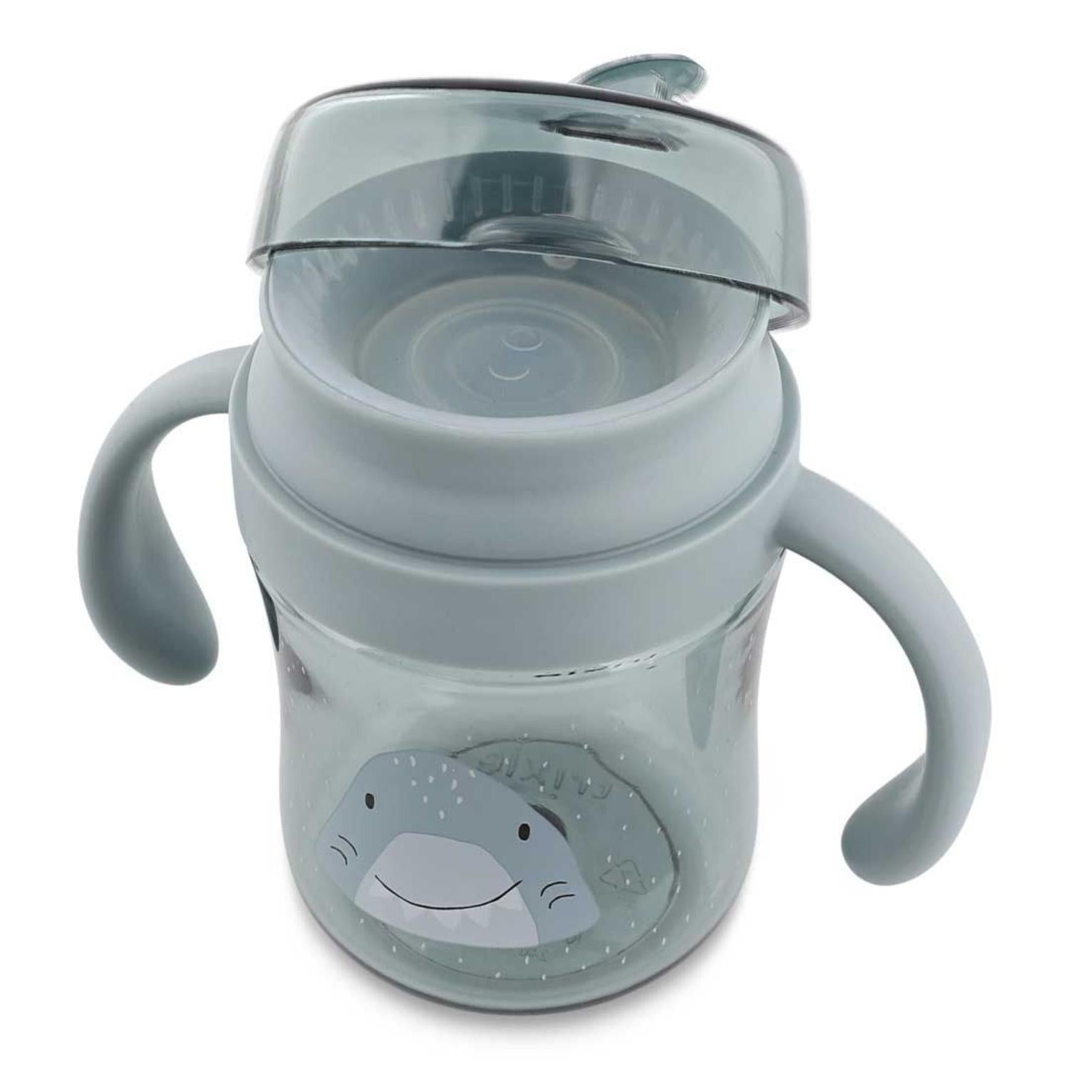 Compra el Vaso Anti-derrame 360 Tiburón de Trixie. Taza de aprendizaje infantil con asas en Tritan™ resistente. Ideal para aprender a beber sin derrames ni goteos.