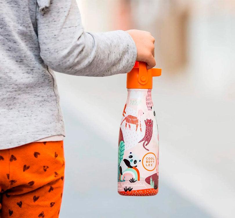 diseño Panda grande de ¡La botella con los pandas más divertidos ya ha llegado a Mano de Santa!  ¡Descubre la botella isotérmica para niños de 36 horas de frío y 18 de calor! Su tecnología Triple Cool™ mantendrá tus bebidas frías y calientes con total comodidad. Foto life style de niño de espaldas sujetando en la mano la botella de la Marca Cool Bottles