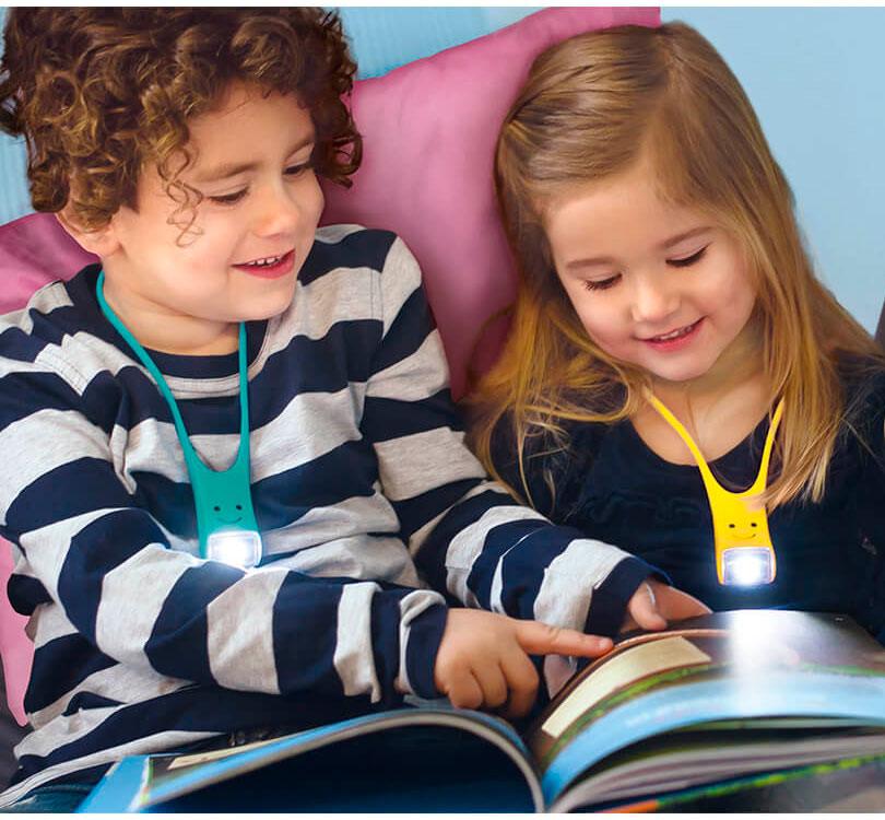 niñas sentadas leyendo libros con la lampara colgante como luz de lectura con forma de pequeño monstruo en color amarillo y turquesa
