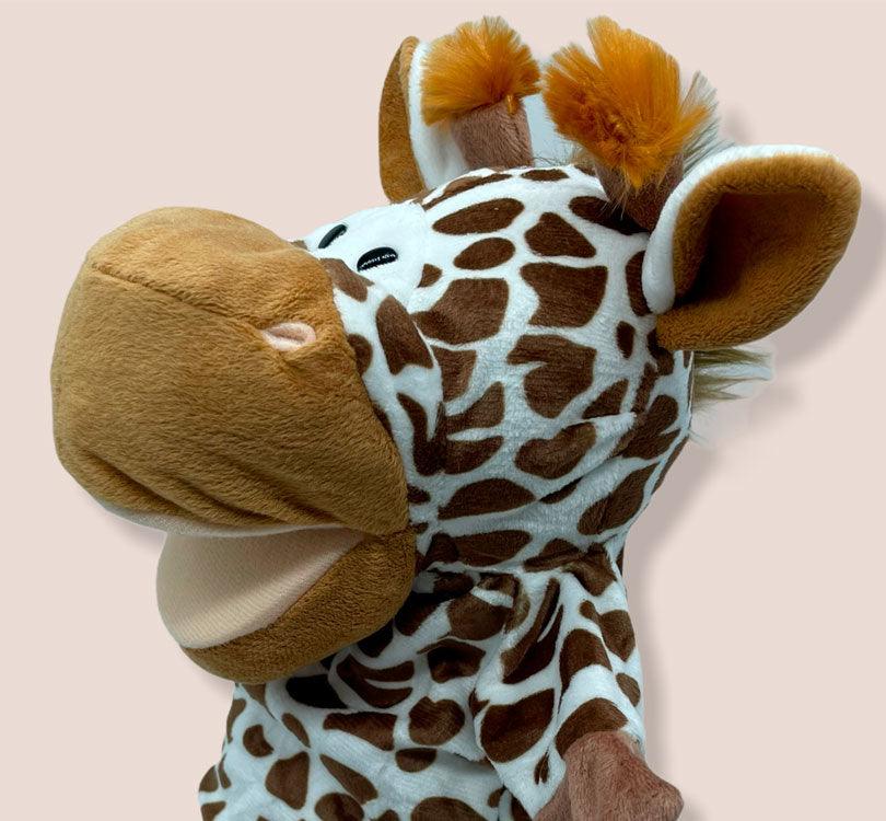 detalle lateral de los cuernos y la boca de la marioneta de mano infanti jirafa alice en tono crema y camel con los cuernos con pompon naranja  