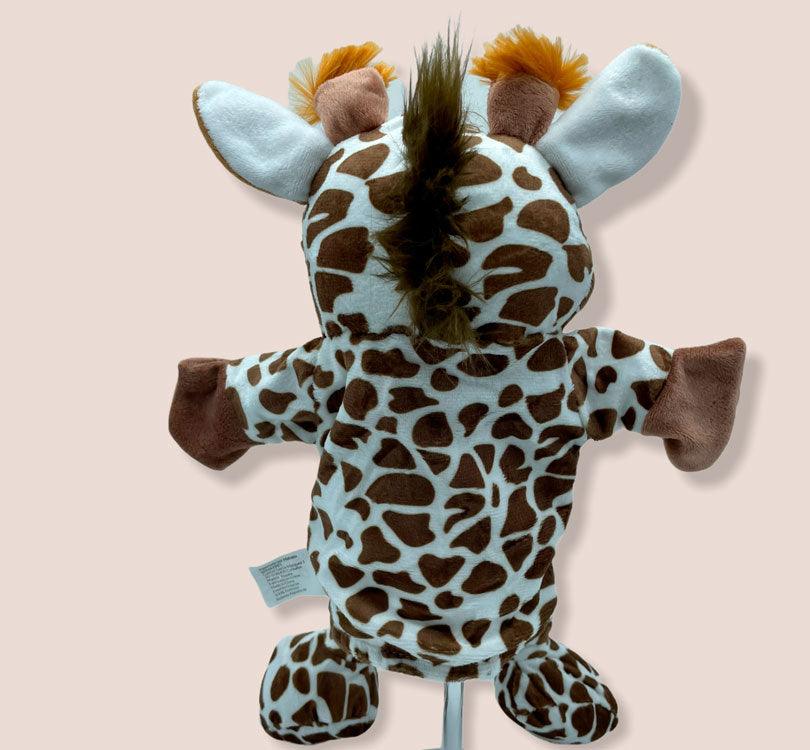 detalle trasera de la espalda y la  cabeza de la marioneta de mano infanti jirafa alice en tono crema y camel con los cuernos con pompon naranja  