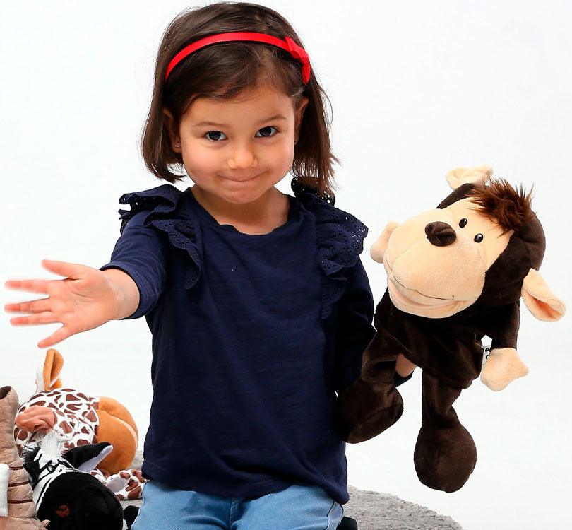 foto de lifestyle de niña sentada en el suelo jugando con marioneta de mano Miki el mono el color marron chocolate y vainilla de la marca mabapu