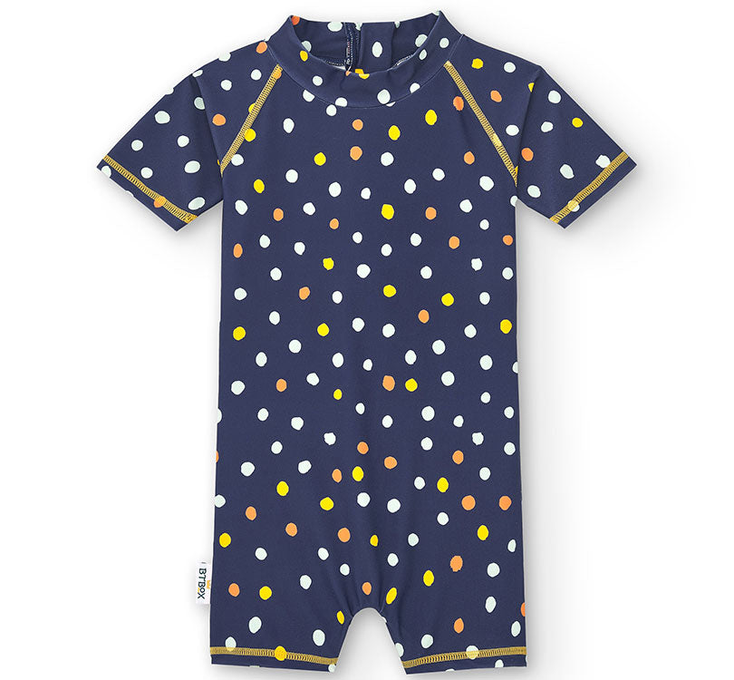 ¿Este verano, quieres proteger a tu bebé del sol de manera cómoda y segura? Descubre el Mono con Protección Solar UPF50+ para bebés de la colección LUNARES NAVY disponible en Manga Corta. Se trata de un Traje Solar UPF50+ de una pieza para bebés que dispone de dos cremalleras para facilitar la puesta y los cambios de pañal&nbsp; Una cierra en la espalda para poner y quitar fácilmente y una cierra en la entrepierna para facilitar el cambio de pañal.