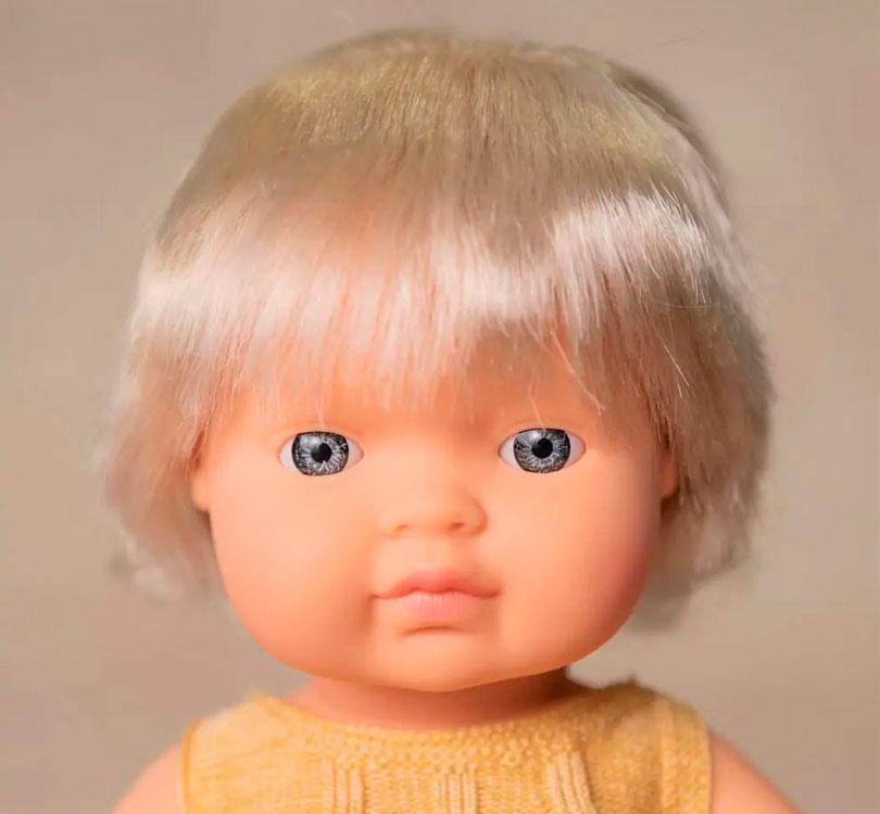 Esta muñeca es una niña nórdica con pelo rubio corto liso, con un adorable pelele mostaza y con implante auditivo. marca Miniland