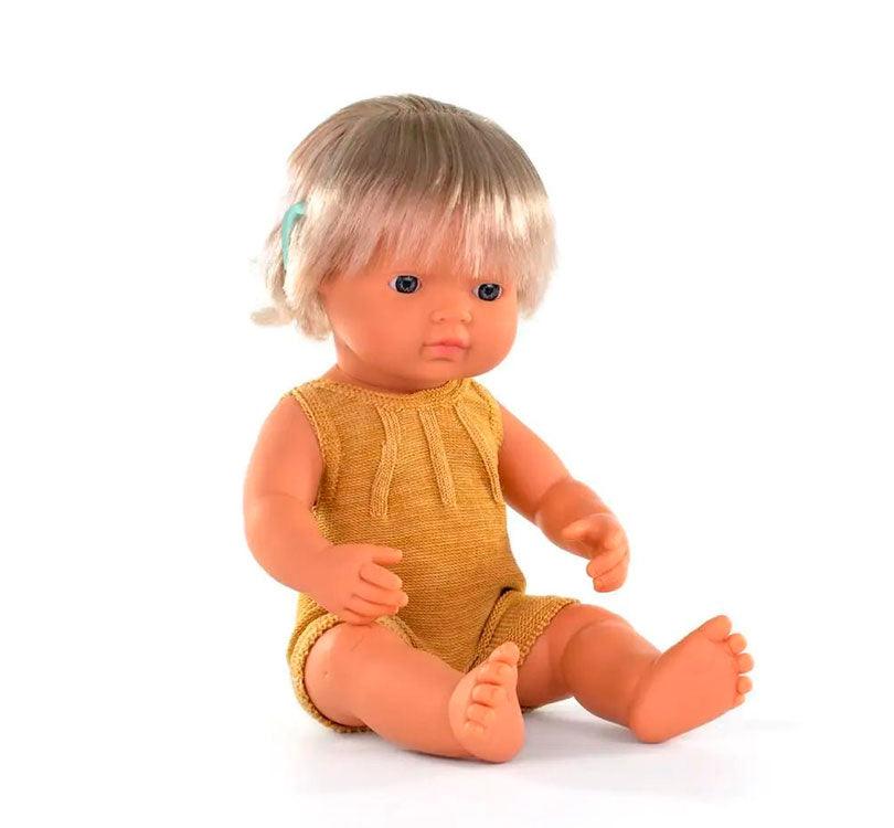 Esta muñeca es una niña nórdica con pelo rubio corto liso, con un adorable pelele mostaza y con implante auditivo. posición sentada marca miniland