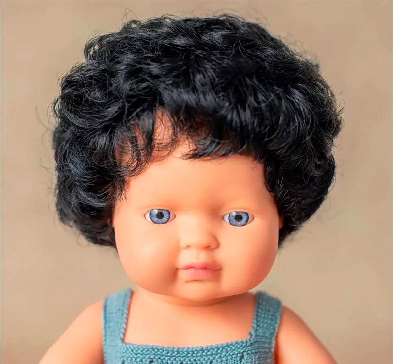 primer plano Este muñeco es un niño nórdico con pelo moreno corto rizado, con un adorable pelele grisáceo. marca Miniland