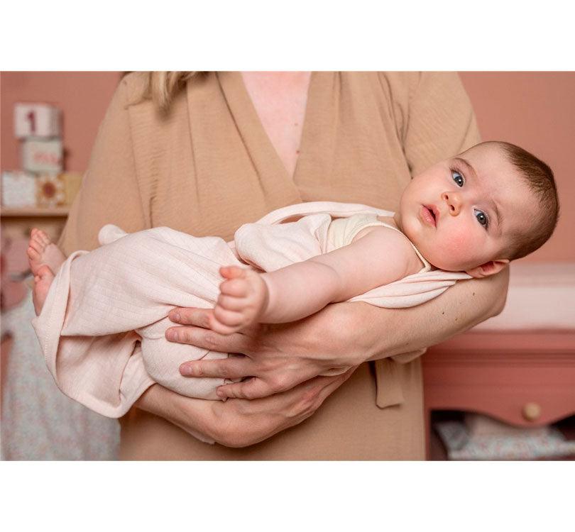 bebe envuelta en una muselina rosa Clarita del  pack de dos muselinas de 70 x 70 cm de algodón organico de la marca Little Dutch. una en color liso y otra estampada, en este caso de la colección ocas en color rosa