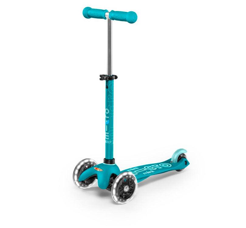 patinete Micro mini deluxe led en color turquesa Aqua vista frontal con las ruedas led encendidas