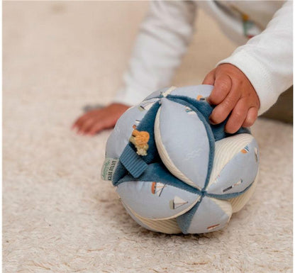 primer plano de las manos de un peque jugando con bola de agarre o pelota montessori de la colección sailors en colores adulones y crema de la marca Little Dutch