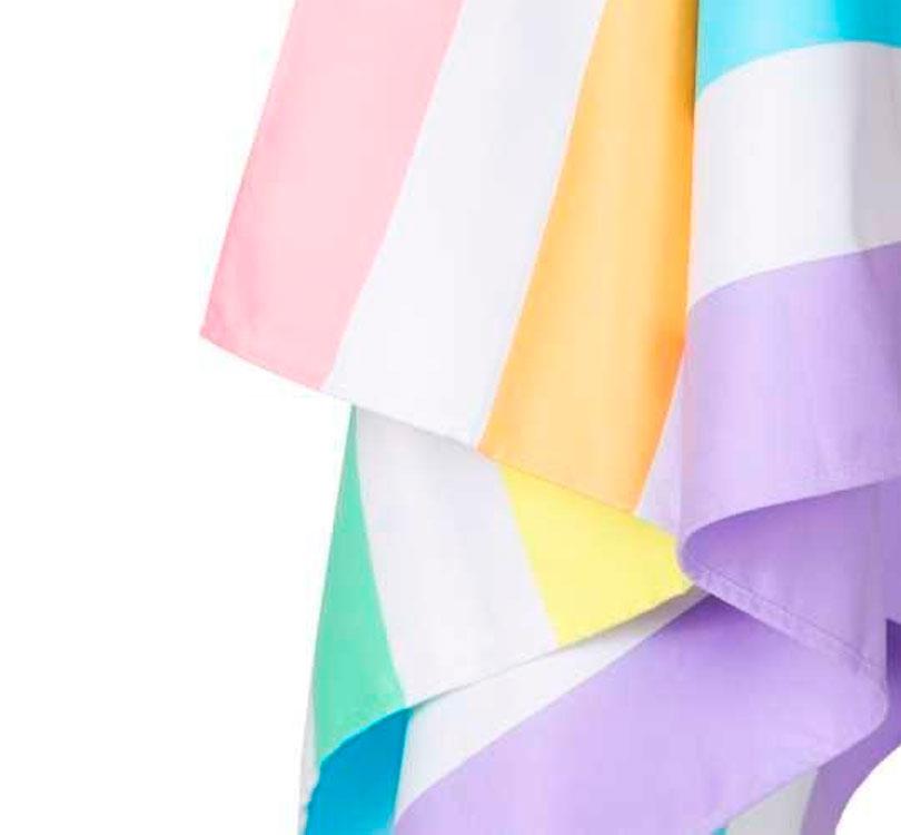 detalle de la tela Toalla antiarena marca dock and bay con estampado de rayas verticales en colores el arcoiris modelo rainbow pastel talla L
